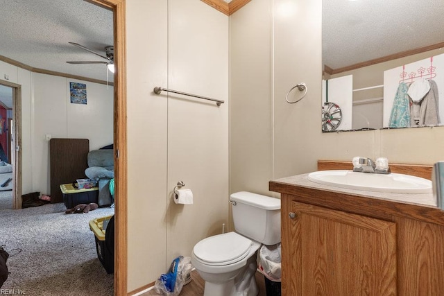 bathroom with toilet, ceiling fan, crown molding, and a textured ceiling