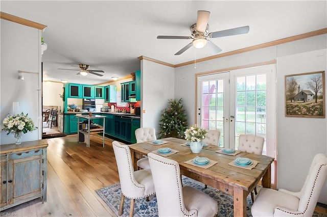 dining room with crown molding, light wood-style flooring, and ceiling fan