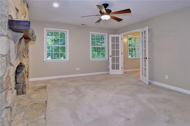 unfurnished living room with carpet, french doors, a ceiling fan, visible vents, and baseboards