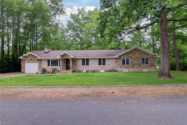 ranch-style home with a garage, a chimney, a front yard, brick siding, and driveway