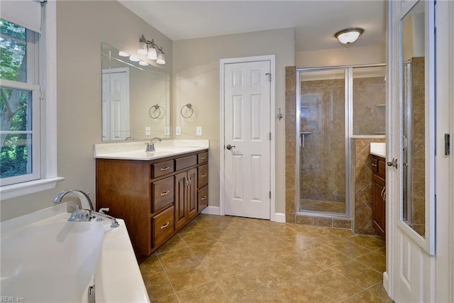 bathroom with a stall shower, vanity, and a healthy amount of sunlight
