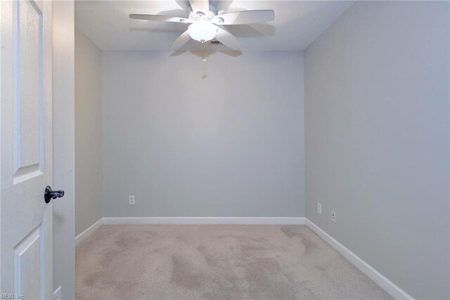 empty room featuring light colored carpet, baseboards, and ceiling fan
