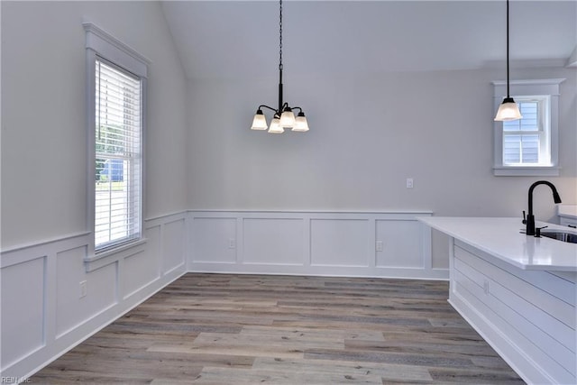 102 Blue Crab Pt, Poquoson, VA 23662 - unfurnished dining area with a sink, a notable chandelier, a decorative wall, wainscoting, and light wood-style floors