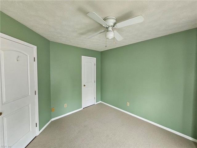 unfurnished bedroom featuring a textured ceiling, baseboards, ceiling fan, and carpet floors