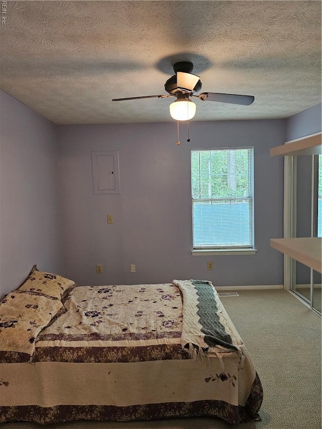bedroom with a textured ceiling, carpet floors, a ceiling fan, and baseboards
