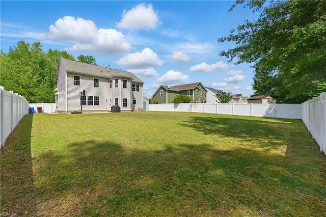 rear view of house featuring a fenced backyard and a lawn
