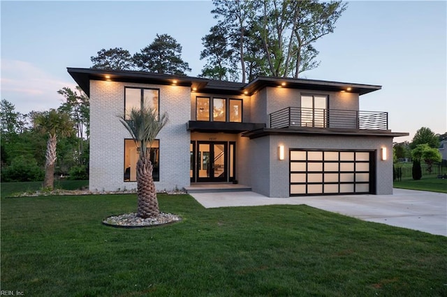 view of front of home featuring an attached garage, concrete driveway, a front lawn, and a balcony