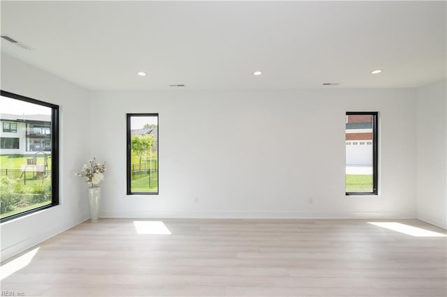 empty room featuring visible vents, light wood-style flooring, and recessed lighting