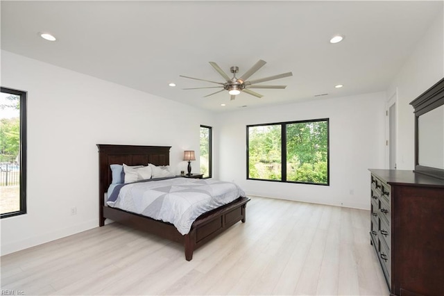 bedroom with multiple windows, light wood-style flooring, and recessed lighting