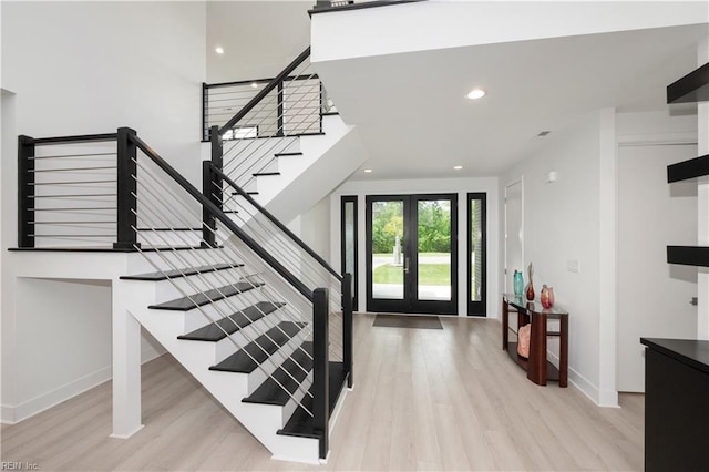 entrance foyer with light wood-type flooring, stairway, baseboards, and recessed lighting