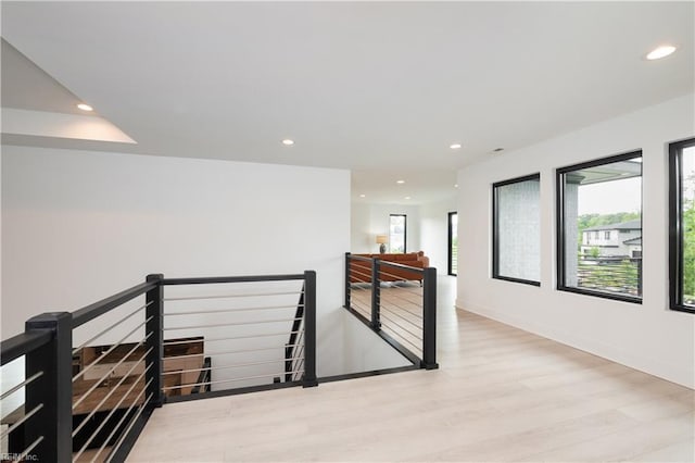 hall featuring wood finished floors, an upstairs landing, baseboards, and recessed lighting