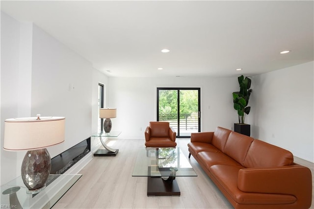 living area featuring baseboards, recessed lighting, and light wood-type flooring