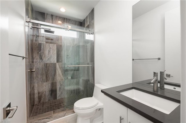 bathroom featuring vanity, toilet, and a stall shower