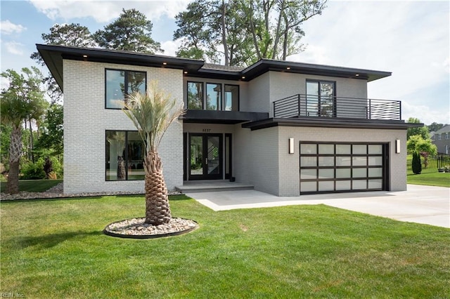 back of house with an attached garage, a yard, a balcony, brick siding, and driveway
