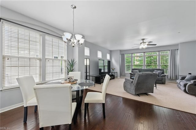 dining room with a chandelier, ceiling fan, dark wood-style flooring, and baseboards