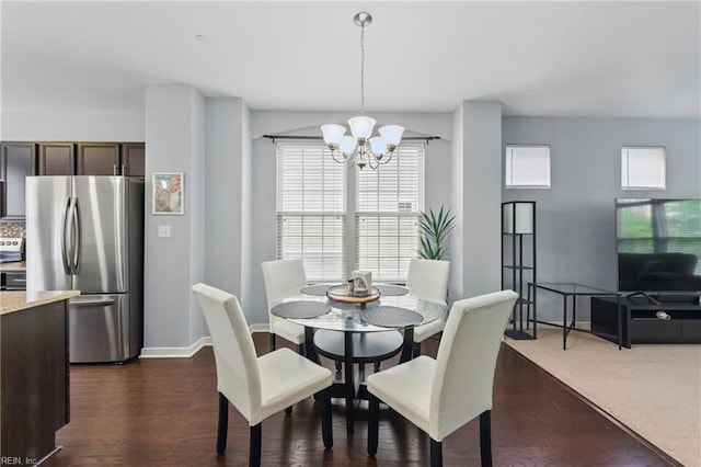 dining room featuring a chandelier, dark wood-style floors, and baseboards