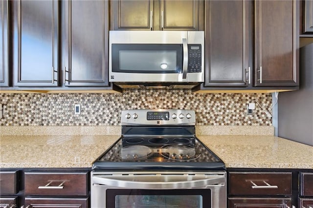 kitchen featuring stainless steel appliances, dark brown cabinets, light countertops, and tasteful backsplash