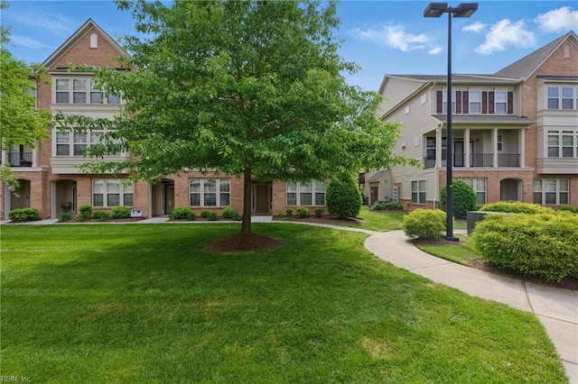 townhome / multi-family property featuring brick siding and a front yard