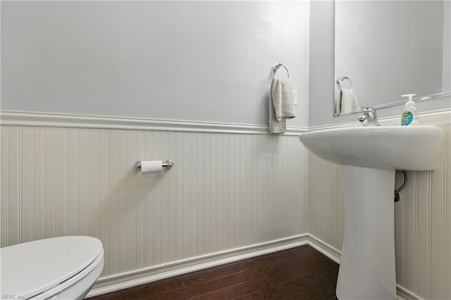 bathroom featuring toilet, wainscoting, and wood finished floors