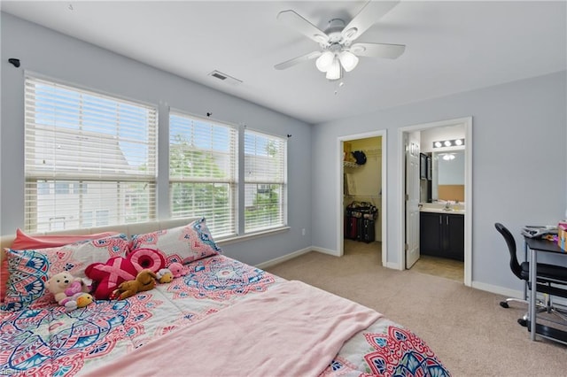 carpeted bedroom with baseboards, a spacious closet, a ceiling fan, and a closet
