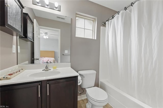 ensuite bathroom featuring vanity, toilet, shower / bath combo, a ceiling fan, and baseboards