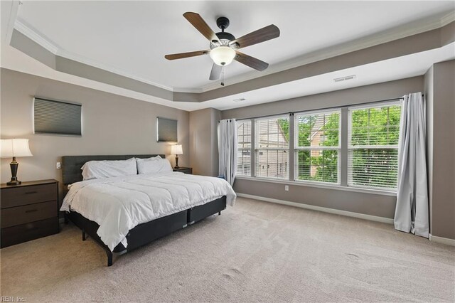 bedroom featuring ornamental molding, carpet flooring, a tray ceiling, and baseboards
