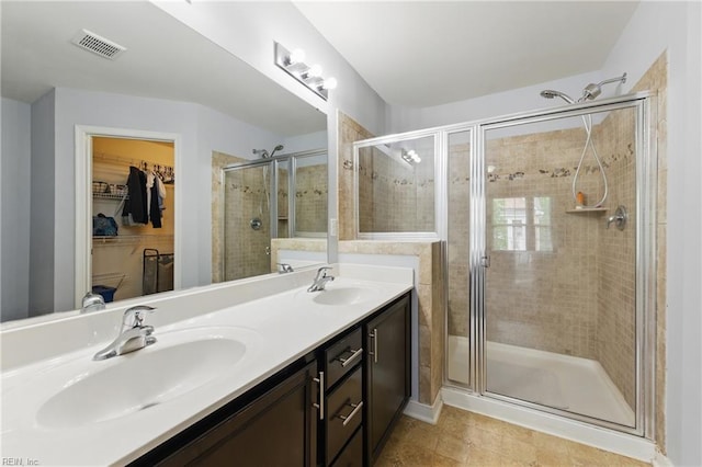full bath with a stall shower, double vanity, and a spacious closet