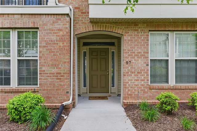 view of exterior entry featuring brick siding