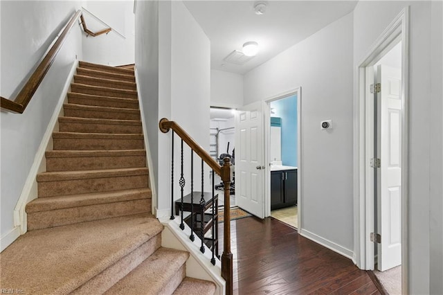 staircase with wood finished floors and baseboards