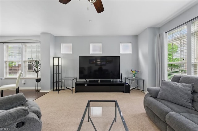 living room featuring ceiling fan, carpet floors, and baseboards