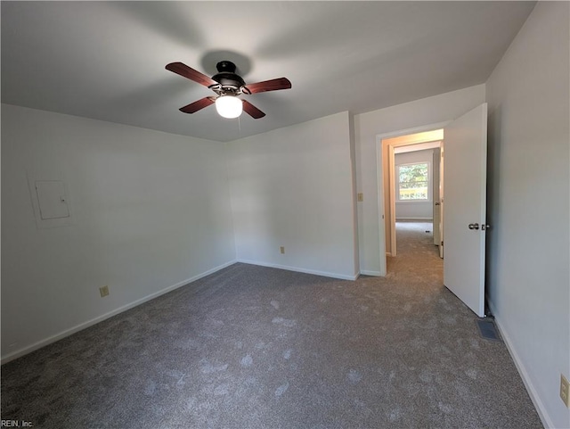 carpeted spare room with baseboards and a ceiling fan