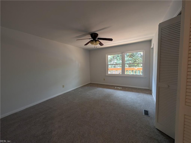 unfurnished bedroom with a closet, baseboards, ceiling fan, visible vents, and dark carpet