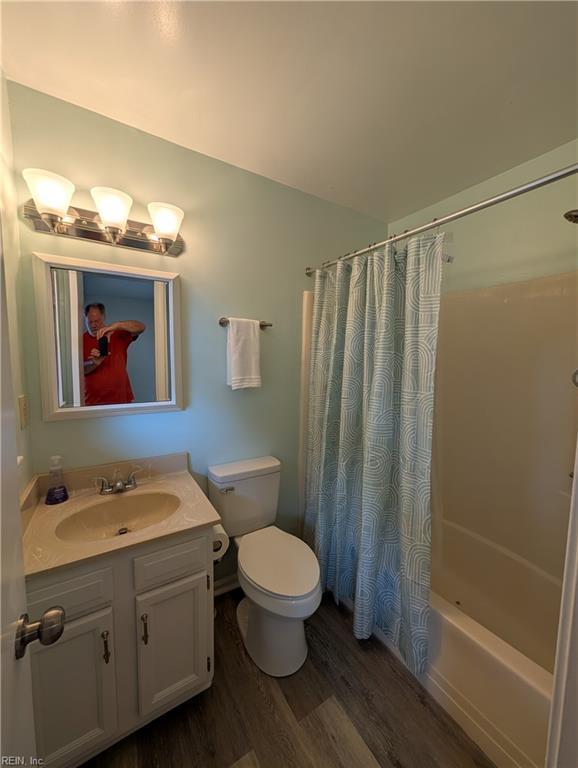 full bathroom featuring vanity, toilet, shower / bath combination with curtain, and wood finished floors