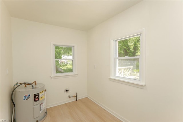 48 Pollux Cir W, Portsmouth, VA 23701 - unfurnished room with water heater, baseboards, and light wood-style floors