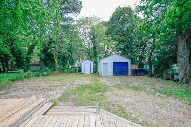 48 Pollux Cir W, Portsmouth, VA 23701 - view of yard with an outbuilding, dirt driveway, a shed, a detached garage, and a deck