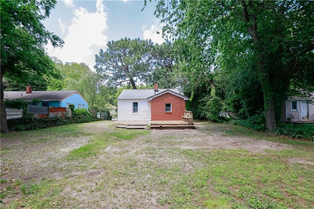 48 Pollux Cir W, Portsmouth, VA 23701 - rear view of house featuring a wooden deck, a chimney, and a lawn