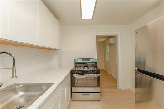 48 Pollux Cir W, Portsmouth, VA 23701 - kitchen featuring a sink, a wall mounted air conditioner, decorative backsplash, white cabinets, and appliances with stainless steel finishes