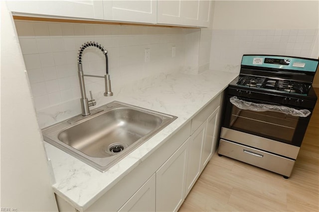 48 Pollux Cir W, Portsmouth, VA 23701 - kitchen featuring stainless steel gas range oven, white cabinets, a sink, and tasteful backsplash