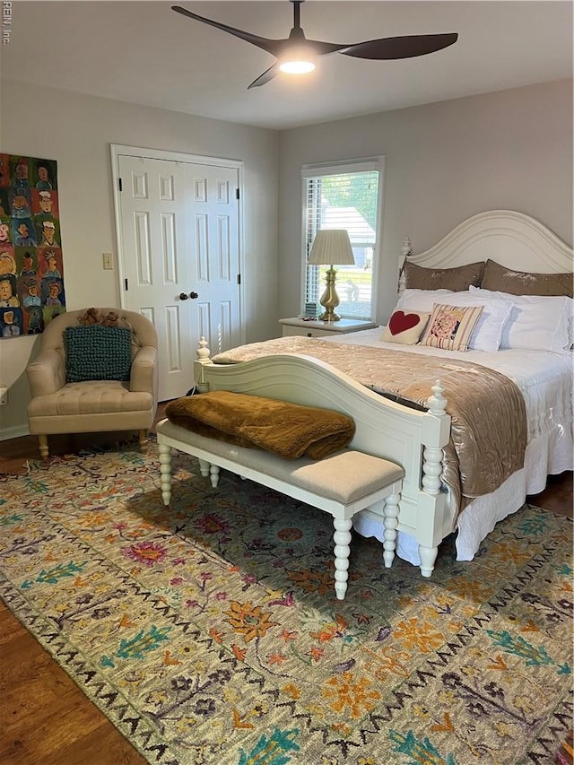 bedroom featuring a closet, wood finished floors, and ceiling fan