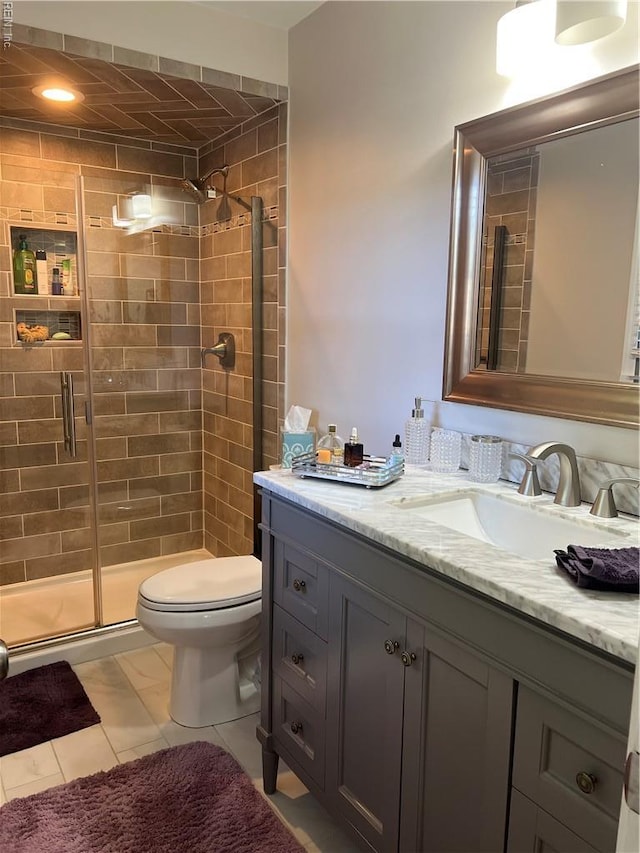 full bath featuring vanity, toilet, and a shower stall