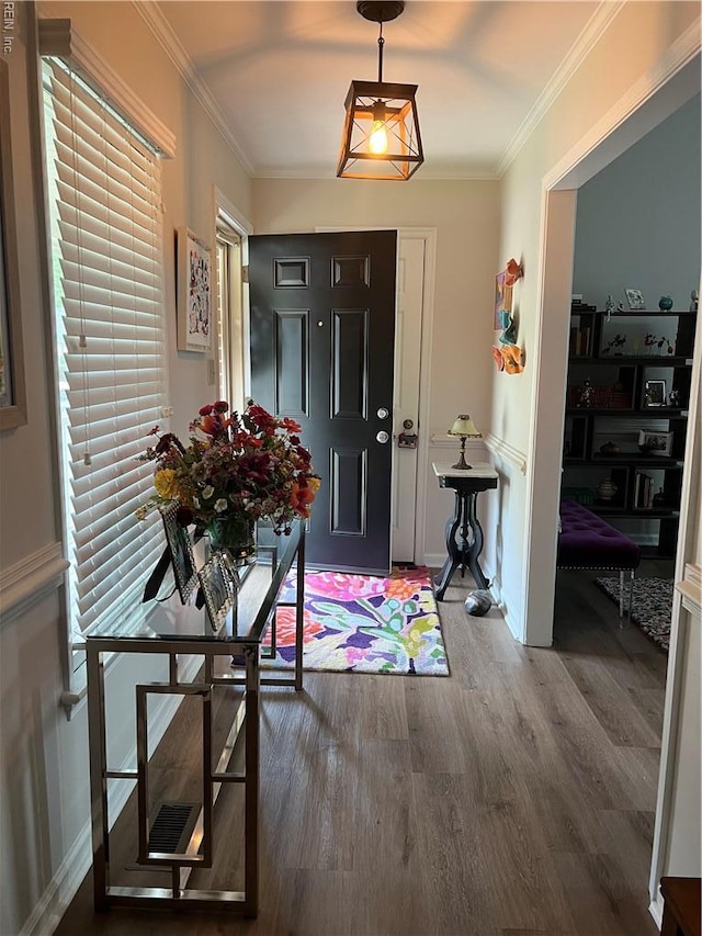 entrance foyer with baseboards, ornamental molding, plenty of natural light, and wood finished floors