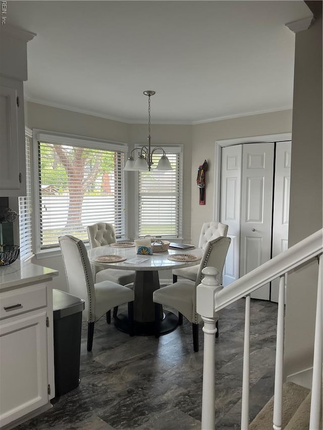 dining area with a chandelier and crown molding
