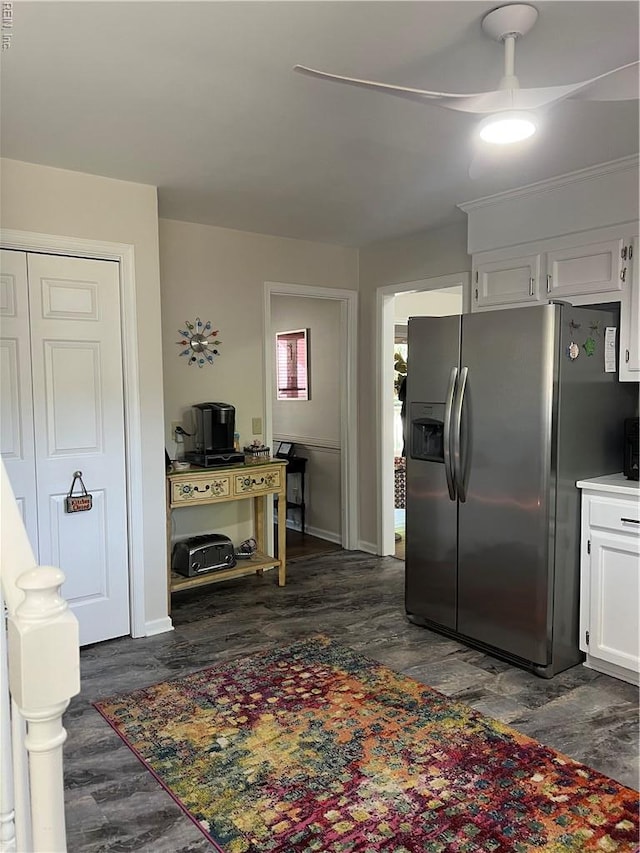 kitchen with stainless steel fridge with ice dispenser, white cabinets, dark wood-type flooring, baseboards, and ceiling fan
