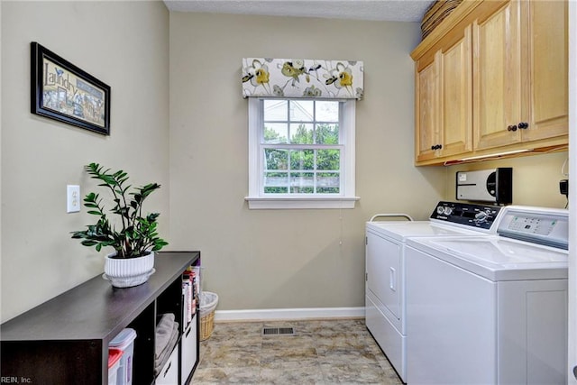 laundry area with cabinet space, independent washer and dryer, and baseboards