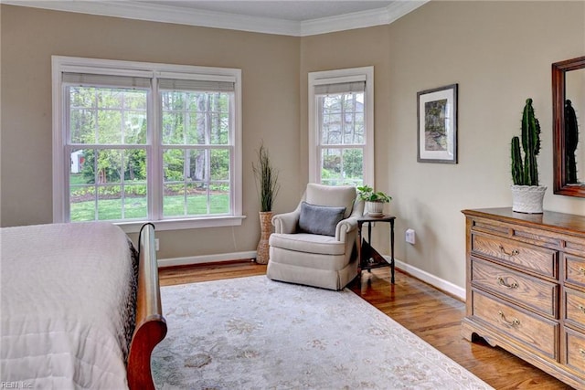 bedroom featuring baseboards, wood finished floors, and ornamental molding