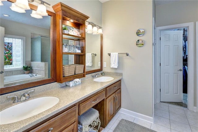 bathroom with tile patterned flooring, double vanity, a walk in closet, and baseboards