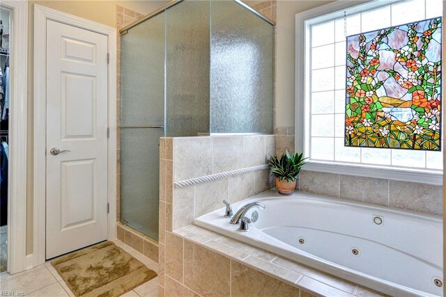 bathroom with a stall shower, a tub with jets, and tile patterned flooring
