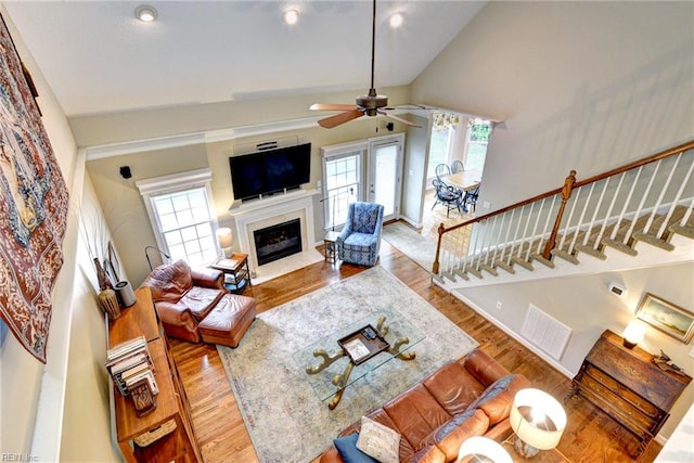 living room featuring wood finished floors, ceiling fan, a high end fireplace, recessed lighting, and lofted ceiling