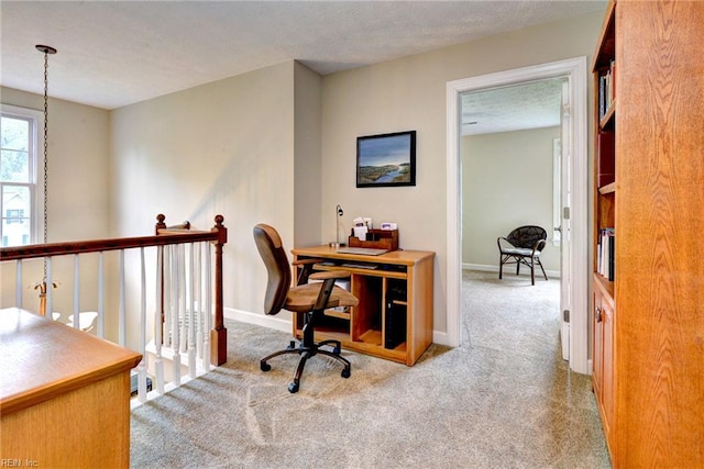 carpeted office featuring baseboards and a textured ceiling