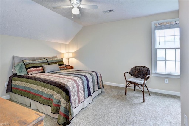 carpeted bedroom with baseboards, a textured ceiling, vaulted ceiling, and ceiling fan